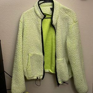 A bright yellow zip up jacket .